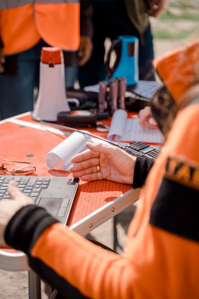 Services Workers collaborating outdoors with laptops and equipment.
